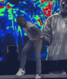 a man is dancing on stage while holding a microphone .