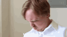 a man in a white shirt is making a funny face and the word what is visible in the corner