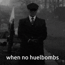 a black and white photo of a man in a suit and hat with the words when no huelbombs below him