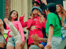 a woman in a red jacket is surrounded by other women