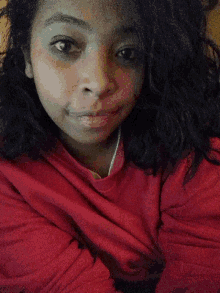 a woman in a red shirt is laying down and smiling