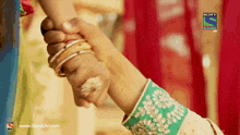 a person holding another person 's hand with a sony television logo on the bottom right