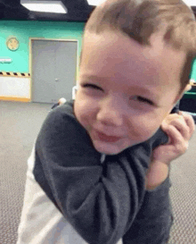 a little boy is smiling and laughing while being held by a person .