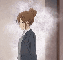 a girl in a suit is standing in front of a door .