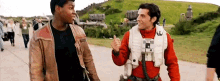 two men are standing next to each other on a road and talking to each other .
