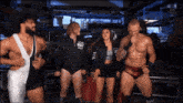 a group of wrestlers are standing in front of a sign that says live