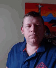 a man wearing a blue polo shirt with a red patch that says ' polo club ' on it