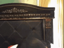 a bed with a black headboard has a gold trim