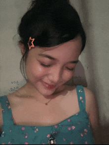a woman wearing a blue top and a star hair clip