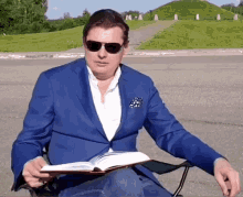a man in a blue suit is reading a book