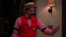 a man is wearing a red vest with a pizza slice on it