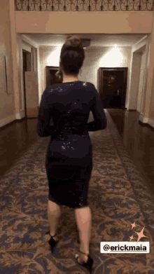 a woman in a black dress is dancing in a hallway with the name erickmaia on the bottom
