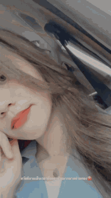 a woman taking a selfie in a car with a smiley face on the bottom right
