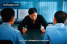 a man sits at a table with two police officers and says i was just ... kidnapped by a mermaid .