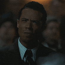 a man in a suit and tie is looking at something