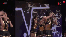 a group of women are dancing in front of a screen that says live on it