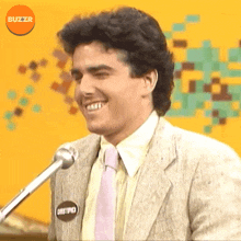 a man in a suit and tie with a buzzr logo on the bottom right