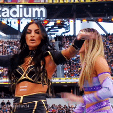 two women are standing in front of a sign that says " stadium "