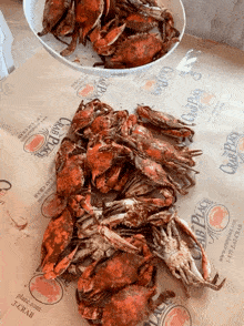 a pile of crabs sits on a table next to a bowl of crabs from the club place