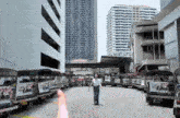 a man walking in front of a row of taxis that say ' i love you ' on the back