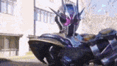 a person in a superhero costume is standing in front of a building and holding a gun .