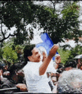 a man in a white shirt is waving a blue flag