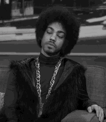 a black and white photo of a man sitting on a couch