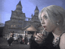 a woman with a lollipop in her mouth is standing in front of a building that says aespagifx