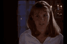 a close up of a woman 's face in a room with candles .