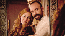 a man with a beard and a woman with long red hair are posing for a picture