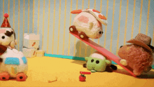 a group of stuffed animals are playing with a red tomato on a table .