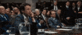 a group of people are sitting around a table and the word ser is visible
