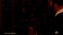 a man is holding a fire while another man looks on with the hashtag #chicagofire