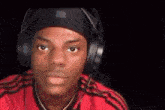 a man wearing headphones and a beanie is making a funny face .