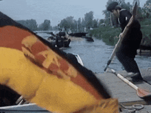 a man in a black hat is holding a flag in front of a german flag