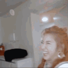 a woman is laughing in a room while a balloon is being thrown at her .