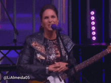 a woman playing a guitar in front of a las estrellas logo