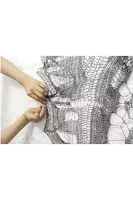 a person is holding a piece of fabric with a pattern