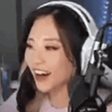 a woman wearing headphones and a microphone is laughing .