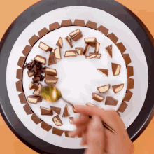 a person is decorating a cake with chocolate candy
