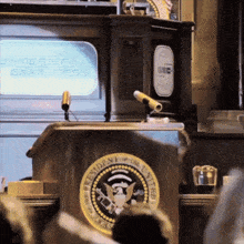 the president of the united states stands at a podium in front of an american express television