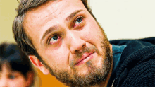 a man with a beard and blue eyes is looking up
