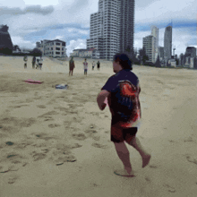 a man running on a beach with a shirt that says ' shark ' on the back