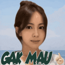a woman 's face is behind a sign that says " gakmau "