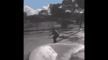 a man is riding a skateboard down a ramp at a skate park .