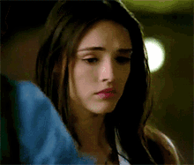 a close up of a woman 's face with a sad expression