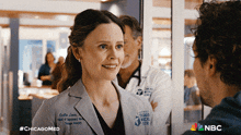 a woman in a chicago medical center coat talks to a man in a hospital