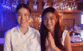 two women are standing next to each other in front of a bar .