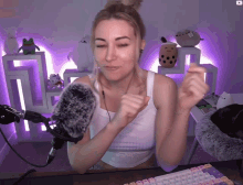 a woman sitting in front of a microphone with a purple background