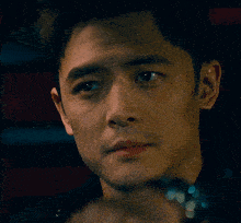 a close up of a man 's face with a watch on his wrist